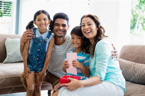 Premium Photo Portrait Of Parents And Kids Sitting On Sofa With