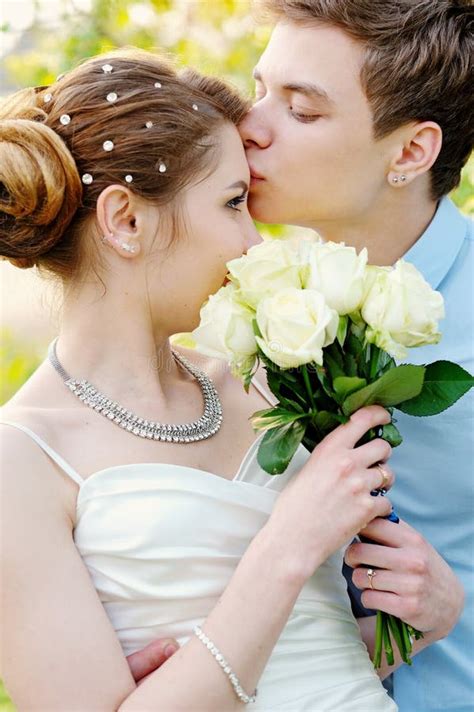 Groom Kisses The Bride On Walk On Their Wedding Day Stock Photo Image