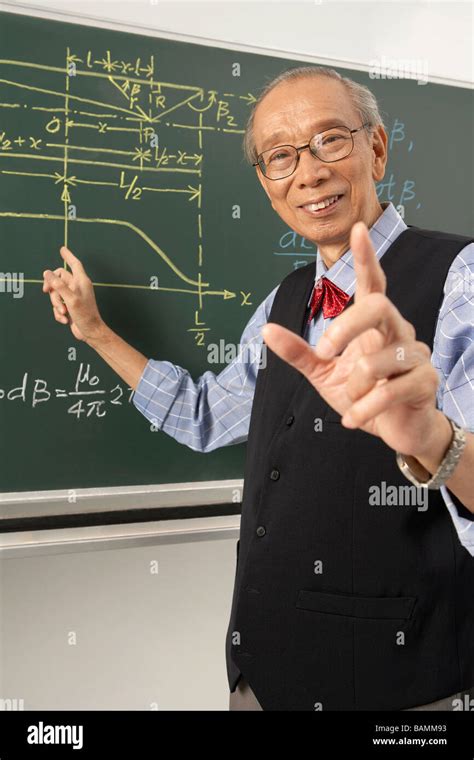 Teacher Pointing To Blackboard Stock Photo - Alamy