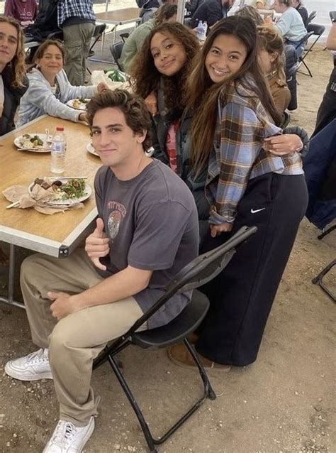 A Group Of People Sitting Around A Table With Food And Drinks On It In