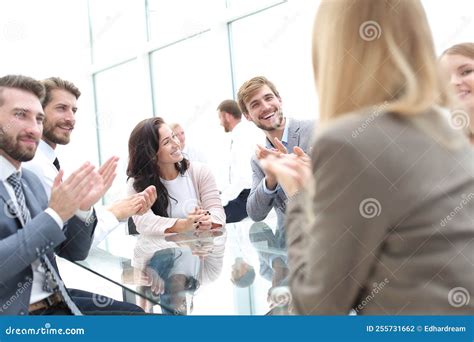 Group Of Business People Applauding Sitting At The Negotiating Table