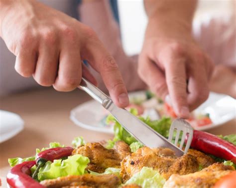 Nahaufnahme hände, die fleisch schneiden | Kostenlose Foto