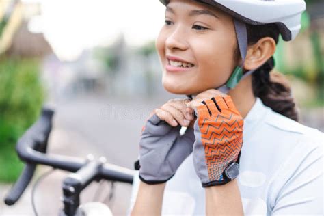 Woman Cyclist Wearing Her Sports Helmet Outdoor in Morning with Road ...