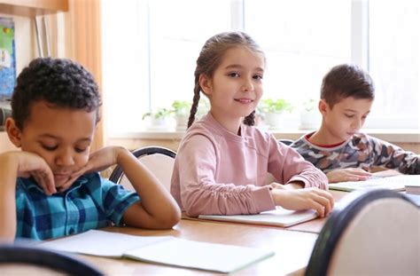 Niños lindos haciendo la tarea en el aula en la escuela Foto Premium