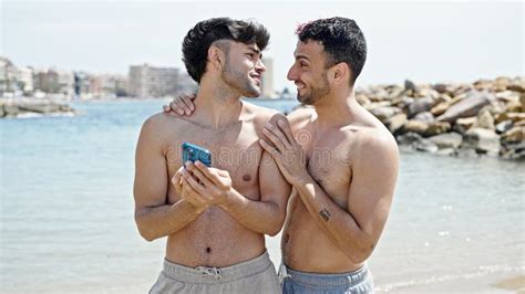 Dos Hombres Pareja De Turistas Sonriendo Confiados Usando Un Smartphone