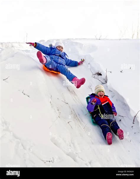 Two Girls On Sled Through The Snow To Slide Stock Photo Alamy