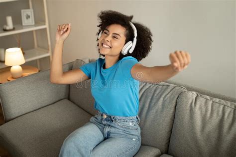 Glad Millennial African American Curly Female In Wireless Headphones