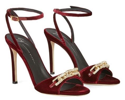 A Pair Of Red High Heeled Shoes With Gold Chains On The Ankle And Straps