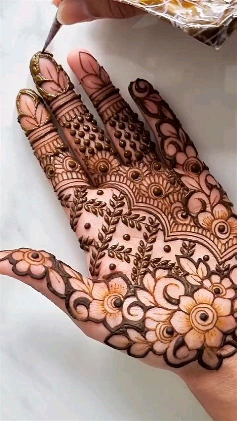 Someone Is Holding Their Hand With Henna On It