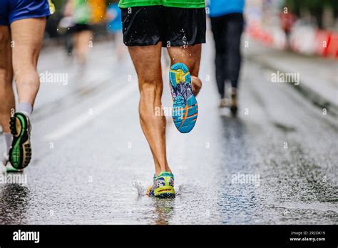 Legs Male Runner Athlete Run Marathon Race On Wet Asphalt Water Drops