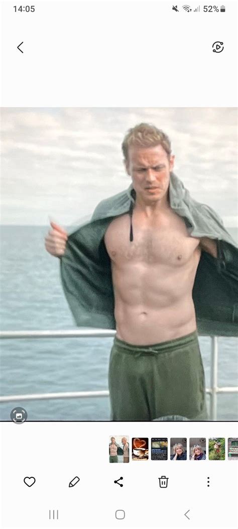 A Man With No Shirt On Standing In Front Of The Ocean Holding His