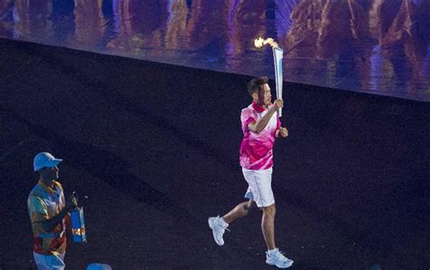 Lin Dan holding the torch and marches to the stadium at the Nanjing ...