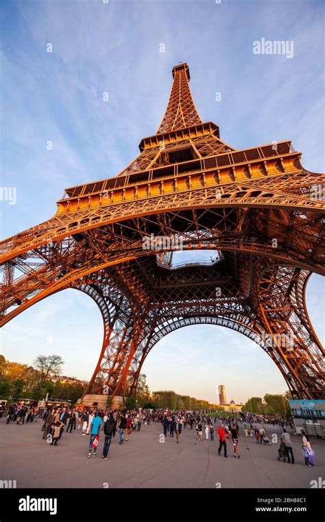 Tourists Walking Under The Base Of The Eiffel Tower In Paris Stock