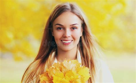 Portrait Of Beautiful Smiling Blonde Woman With Yellow Maple Leaves In