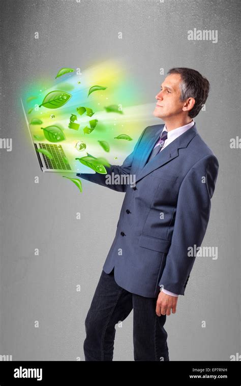 Businessman Holding Laptop With Recycle And Environmental Symbols Stock