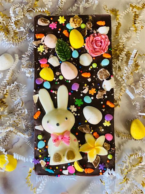 a chocolate card with an image of a bunny and flowers on it, surrounded by confetti