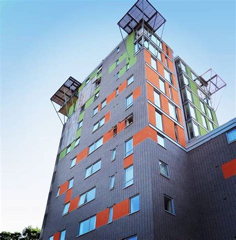 An Orange And Green Building With Lots Of Windows