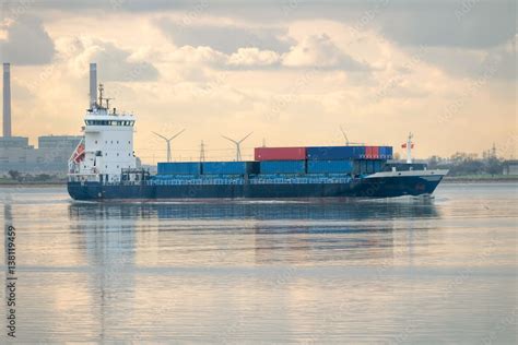 Feeder ship. Cargo container vessel on industrial river. Stock Photo | Adobe Stock