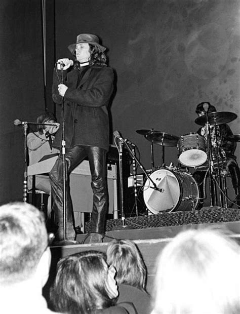 A Man Standing On Top Of A Stage Next To A Microphone In Front Of A Crowd