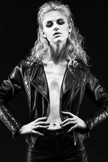 Daring Girl Model In Black Leather Dress In The Style Of A Rock On A