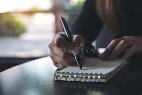 Un S De Femme Remet Noter Sur Un Carnet Vide Blanc Sur La Table Photo