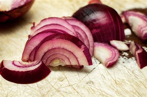 Rodajas De Cebollas Rojas En Una Tabla De Cocina De Madera Foto Premium