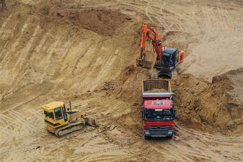 Excavator Moving Earth and Unloading into a Dumper Truck Stock Image ...