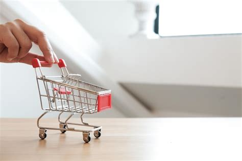 Premium Photo Cropped Hand Holding Shopping Cart At Home