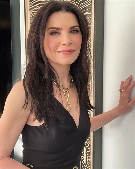 A Woman In A Black Dress Leaning Against A Wall With Her Hand On The Door