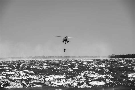 A U.S. Coast Guard rescue swimmer ascends into a helicopter - NARA & DVIDS Public Domain Archive ...