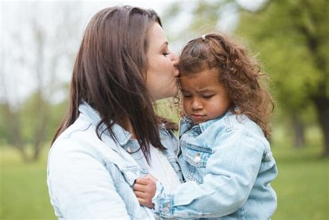 Parc d amour et mère embrassent l enfant avec une expression