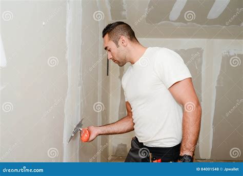 Construction Industry Worker With Tools Plastering Walls And Renovating