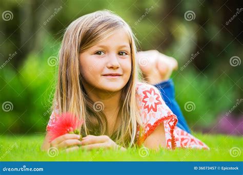 Portrait D Une Petite Fille De Sourire Se Trouvant Sur L Herbe Verte