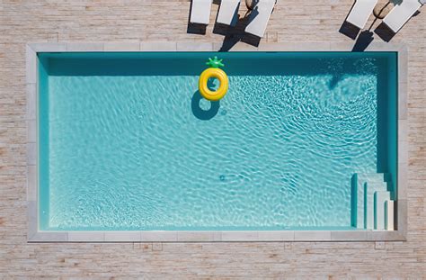 Empty Rectangular Blue Swimming Pool With Sunbeds And Umbrellas And Big