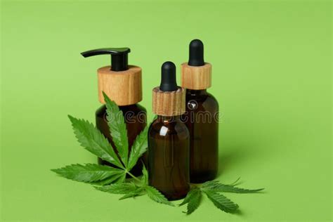 Bottles with Oil and Cannabis Leaves on Green Background Stock Image ...