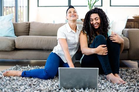 Smiling Lesbian Couple Sitting On Rug And Using Laptop Stock Photo Image Of Enjoyment