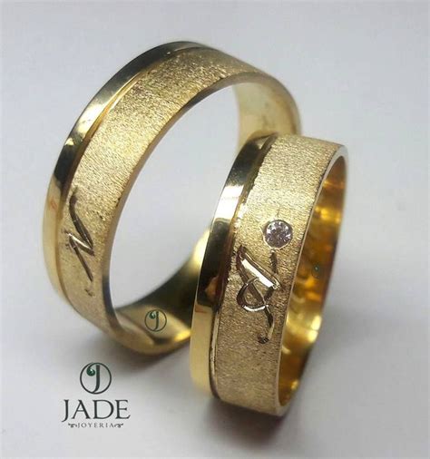 Two Gold Wedding Rings With Diamonds On Each One And The Word Love