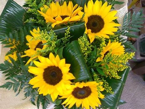 A Bouquet Of Yellow Sunflowers And Greenery