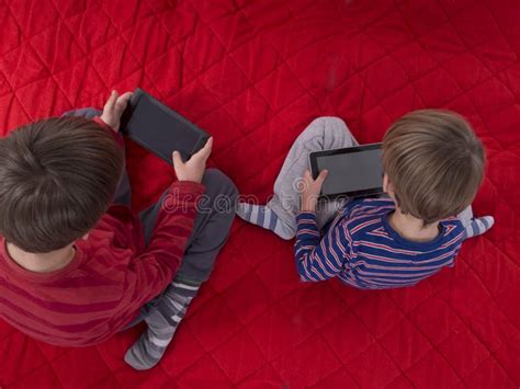 Meninos Que Jogam Jogos Em Computadores Da Tabuleta Foto De Stock