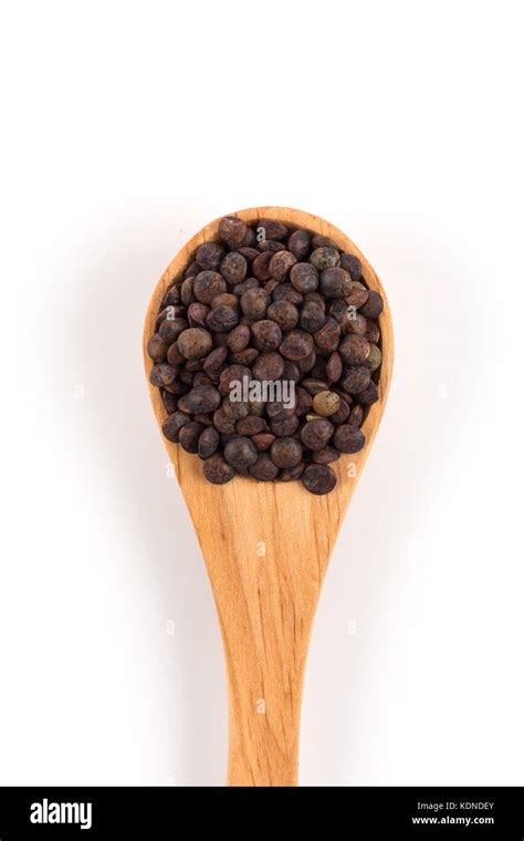 Brown Organic Lentils In Wooden Spoon Isolated On White Background