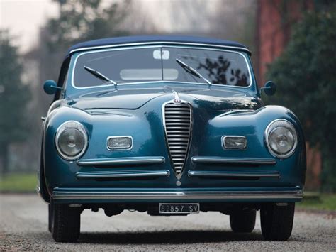 An Old Blue Car Is Parked On The Street