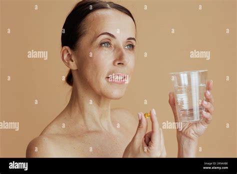 Modern 40 Years Old Woman With Glass Of Water And Pill Isolated On