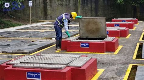 A Man In Safety Gear Is Working On Some Red Boxes