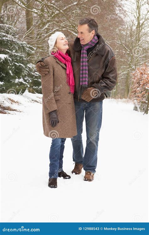 Senior Couple Walking Through Snowy Woodland Stock Image Image Of