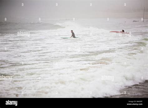 Surfing waves of Far Rockaway Beach during very foggy day New York USA ...