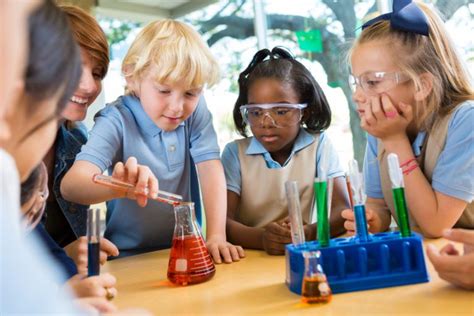 Elementary School Students Doing Chemistry Science Experiment In Class