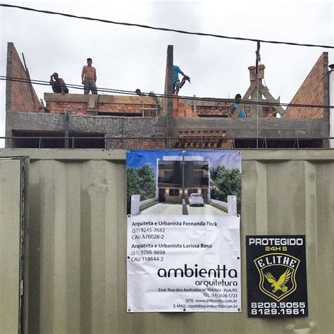 Some People Are Standing On Top Of A Building With A Sign In Front Of Them