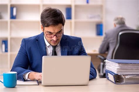 Jefe Masculino Viejo Y Empleado Joven En La Oficina Foto De Archivo