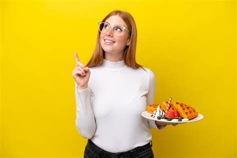 Mulher Jovem Ruiva Segurando Waffles Isolados Em Fundo Amarelo