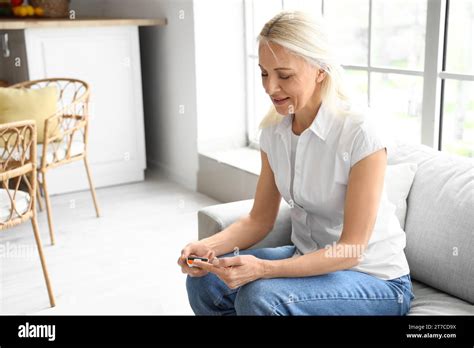 Mature Diabetic Woman Measuring Blood Sugar Level With Glucometer At Home Stock Photo Alamy